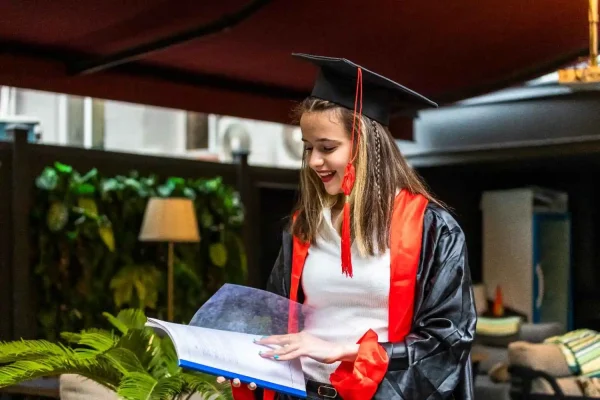 young-student-wearing-graduation-cape-looking-her-notebook-100kb St Mary's University London medicine